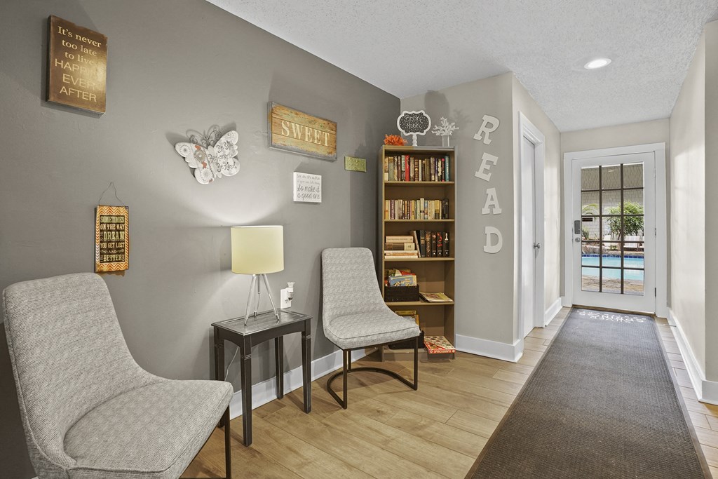 A living room with a chair, a table, and a bookshelf.