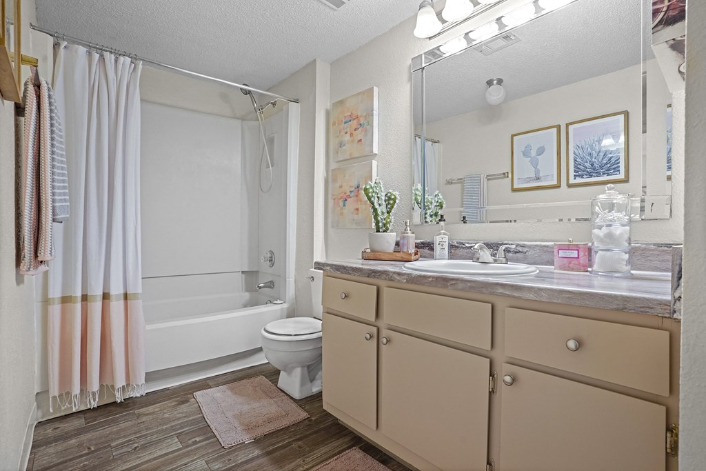 A bathroom with a white toilet, a sink, and a shower curtain.