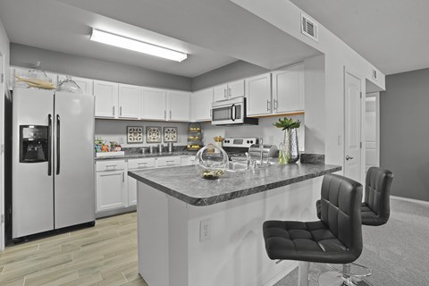A kitchen with a black chair and a counter.