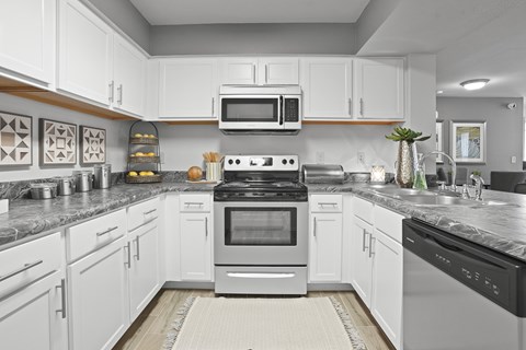A modern kitchen with white cabinets and appliances.