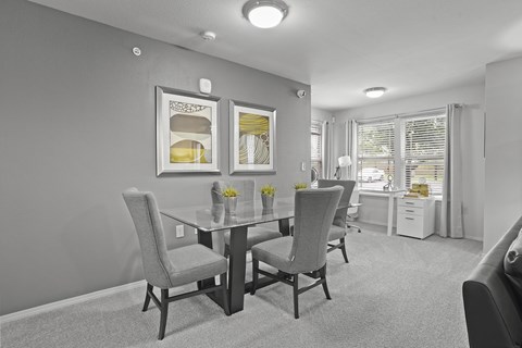 A dining room with a table and chairs.