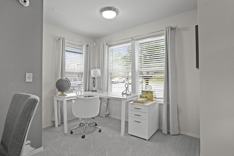 A white room with a desk and a chair.