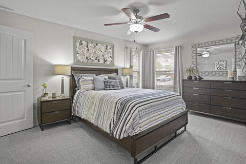 A bedroom with a bed, dresser, and mirror.