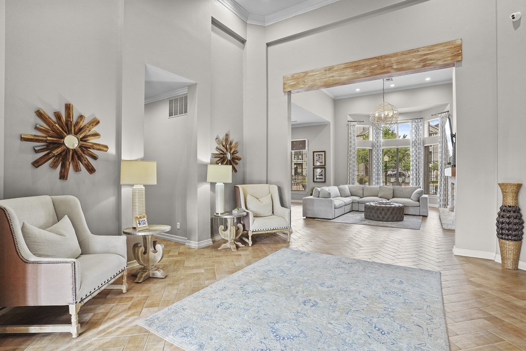 A living room with a white sofa, a wooden table, and a large mirror.