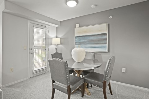 A dining room with a table and chairs.