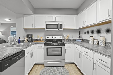 A modern kitchen with white cabinets and a central island.