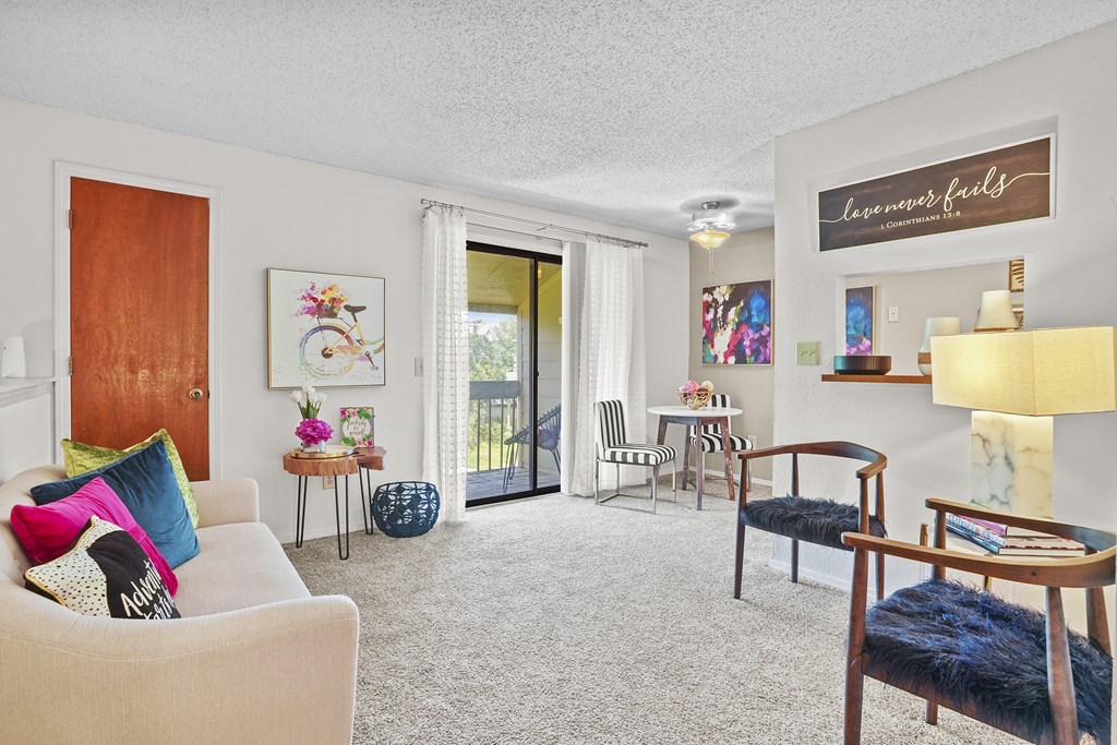 A living room with a white couch and a wooden chair.