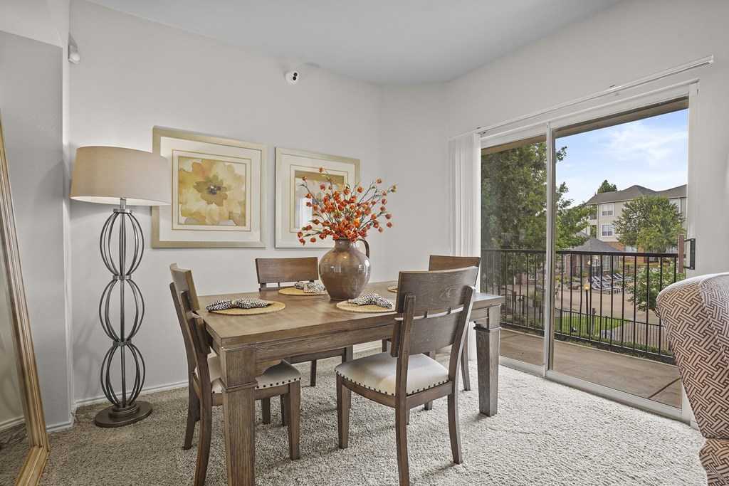 A dining room with a wooden table and chairs.