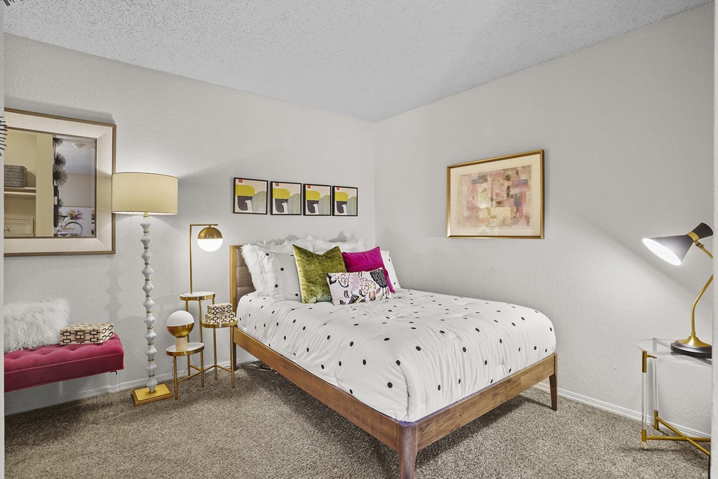 A bedroom with a bed, nightstands, and a painting on the wall.