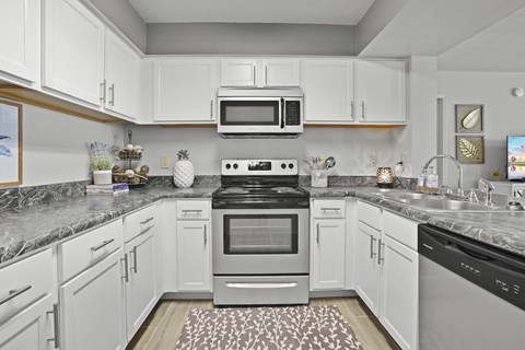 A kitchen with white cabinets and a black stove top oven.
