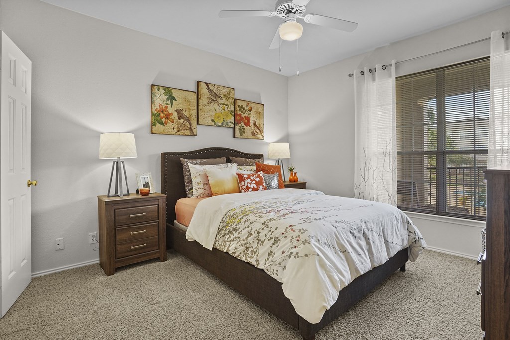 A bedroom with a large bed and a ceiling fan.