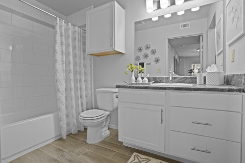 A white bathroom with a toilet, sink, and bathtub.
