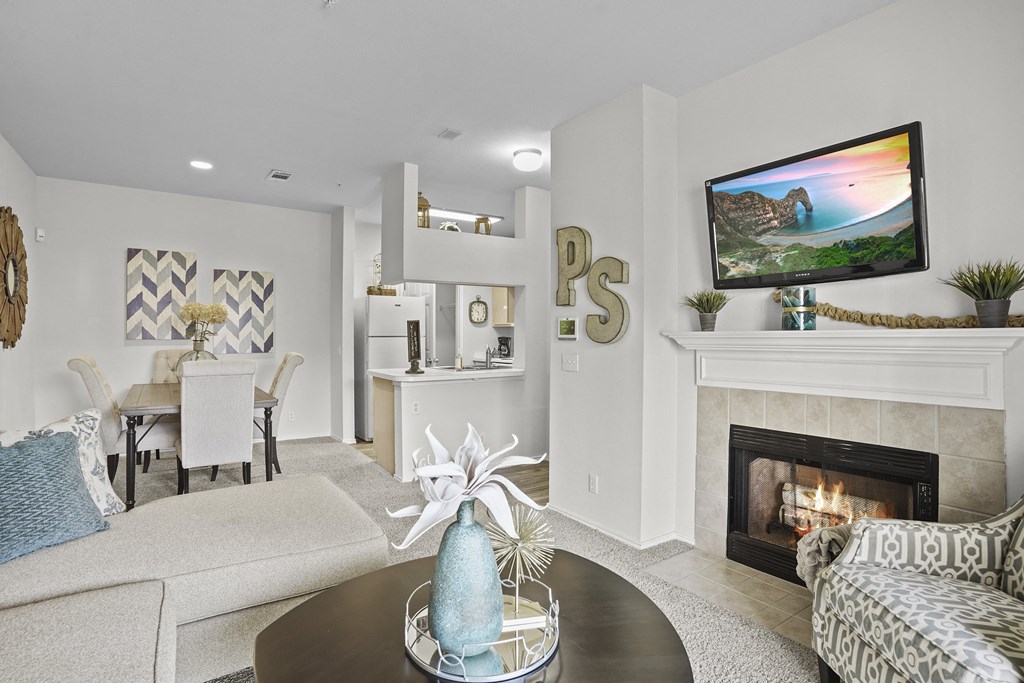 A living room with a fireplace and a TV on the wall.