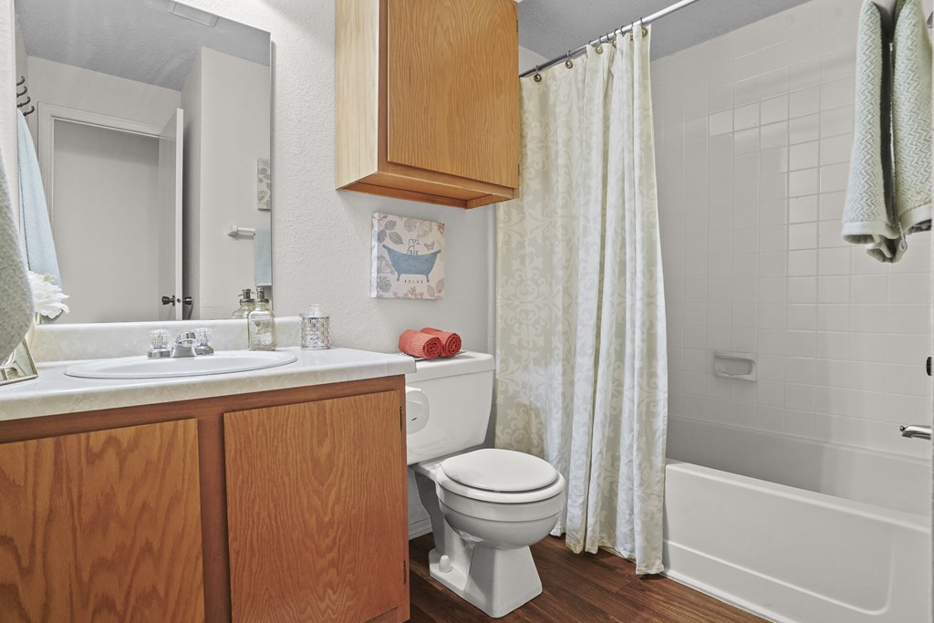 A white toilet sits in a bathroom next to a white sink.
