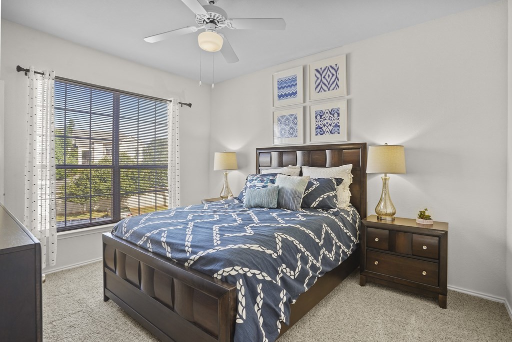 A bedroom with a large bed and a ceiling fan.
