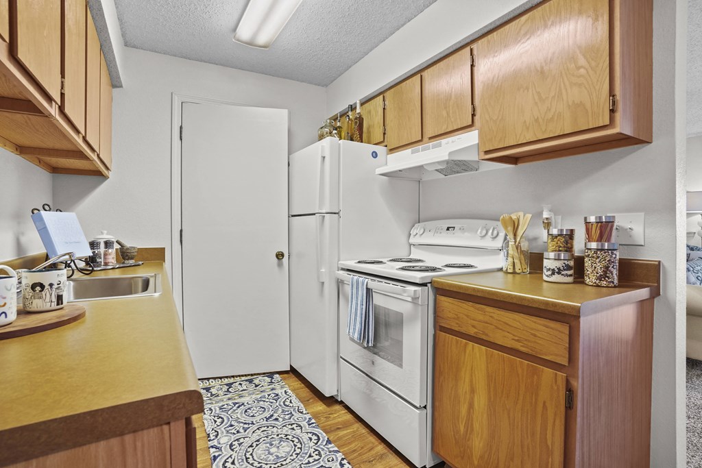A kitchen with wooden cabinets and a white refrigerator.