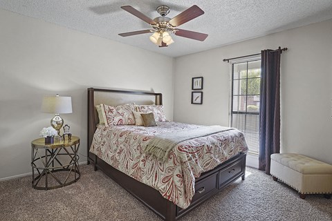 A bedroom with a large bed and a ceiling fan.