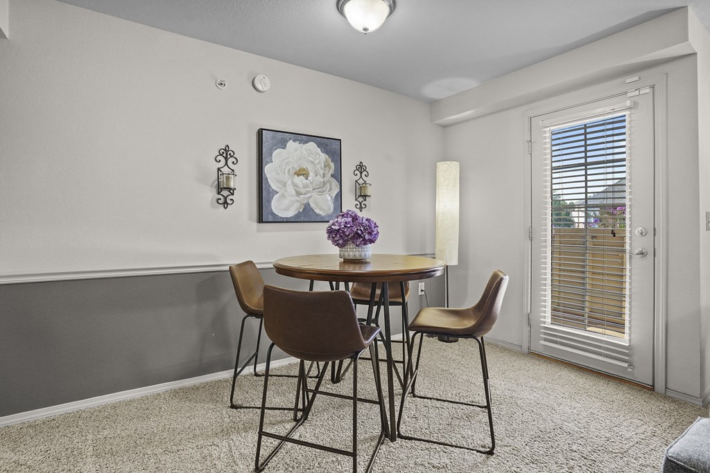A dining room with a table and chairs.