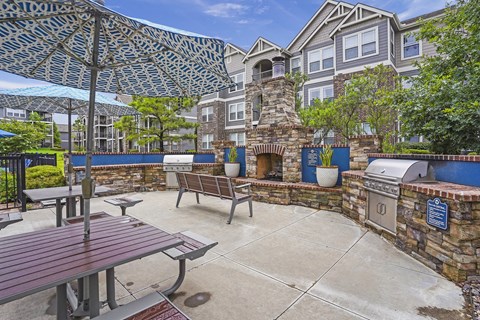 A patio with a table and chairs under a shade sail.