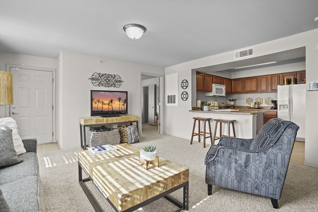 A living room with a grey couch, a coffee table, and a blue armchair.