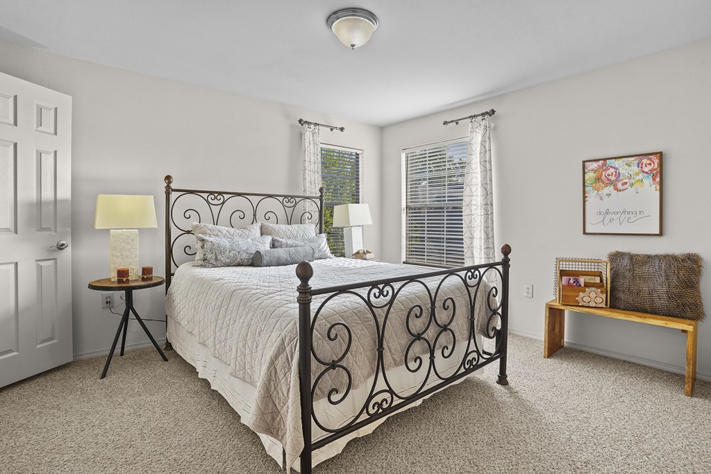 A bedroom with a large bed and a bench.