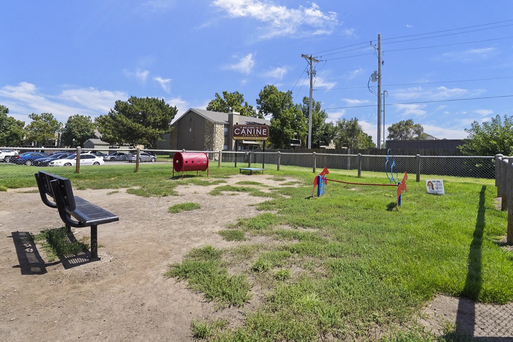 A park with a bench and a sign that says "CANINE".