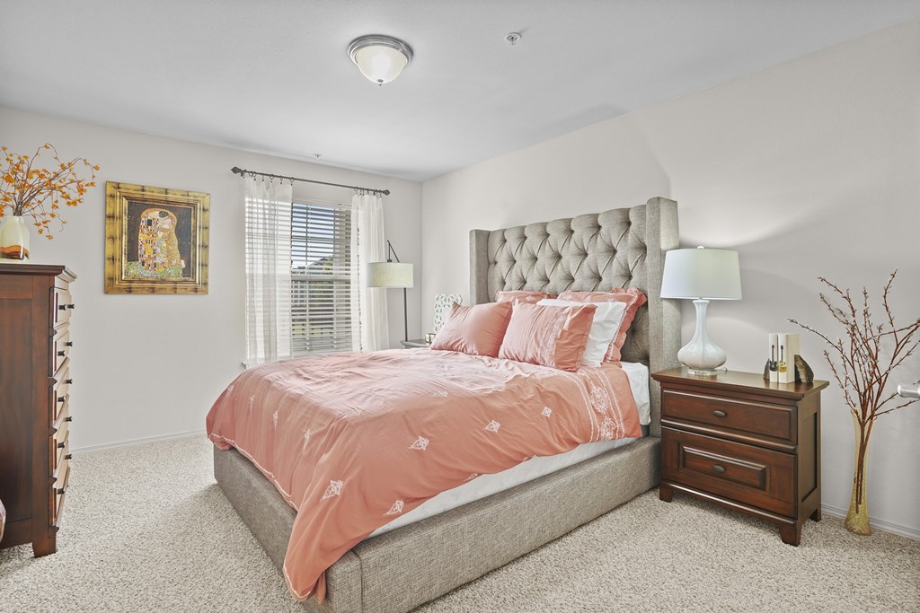 A bedroom with a large bed and a painting on the wall.