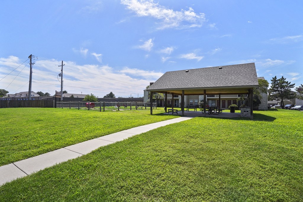 A building with a grey roof is surrounded by a grassy area.