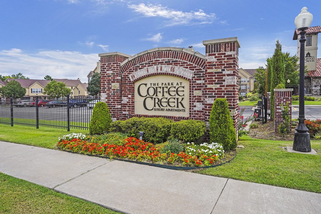 The entrance to The Park at Coffee Creek is adorned with a beautiful flower bed.