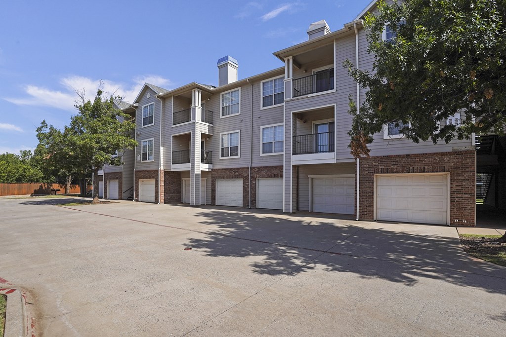 A large apartment complex with a parking lot in front.