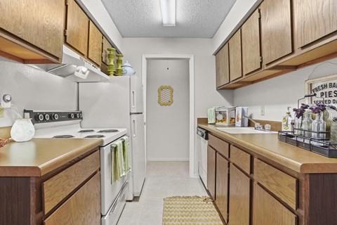 A kitchen with wooden cabinets and a sign that says "Fresh Bar Pies Served Daily".