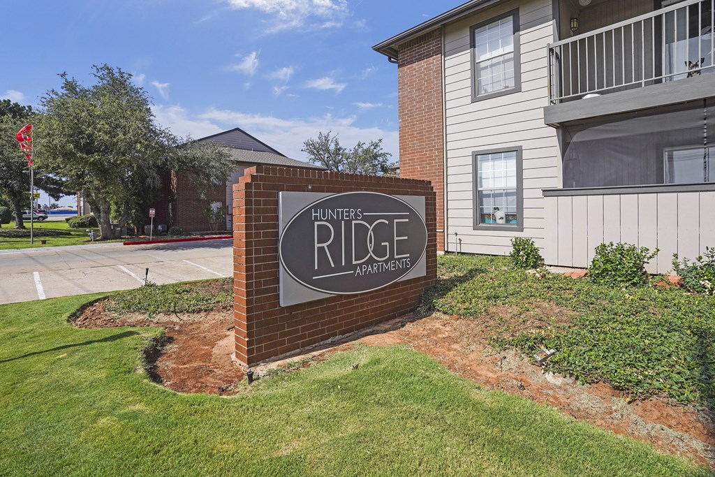 A sign for Ridge Apartments is in front of a building.