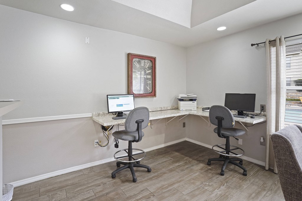 A room with two chairs and two computers.