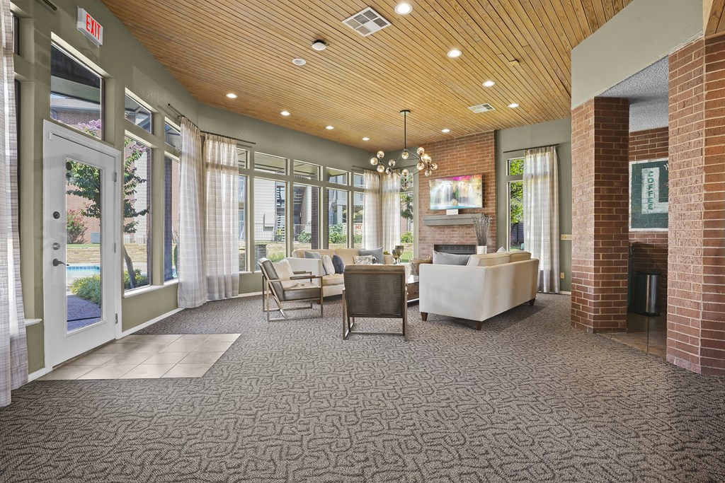 A living room with a couch, chairs, and a rug.