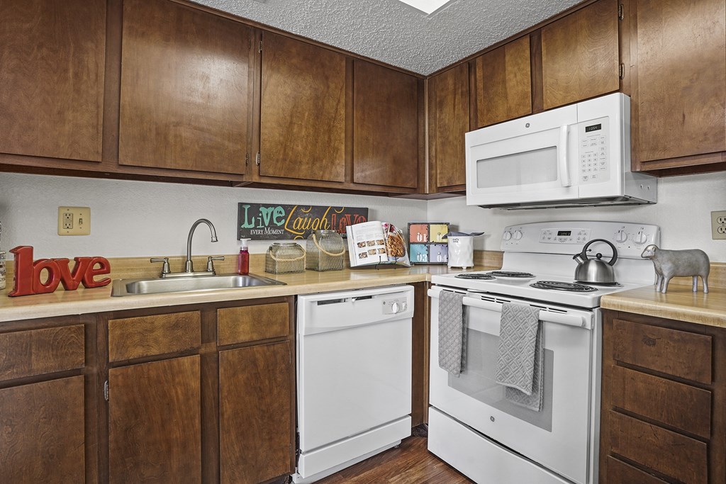 A kitchen with wooden cabinets and white appliances.