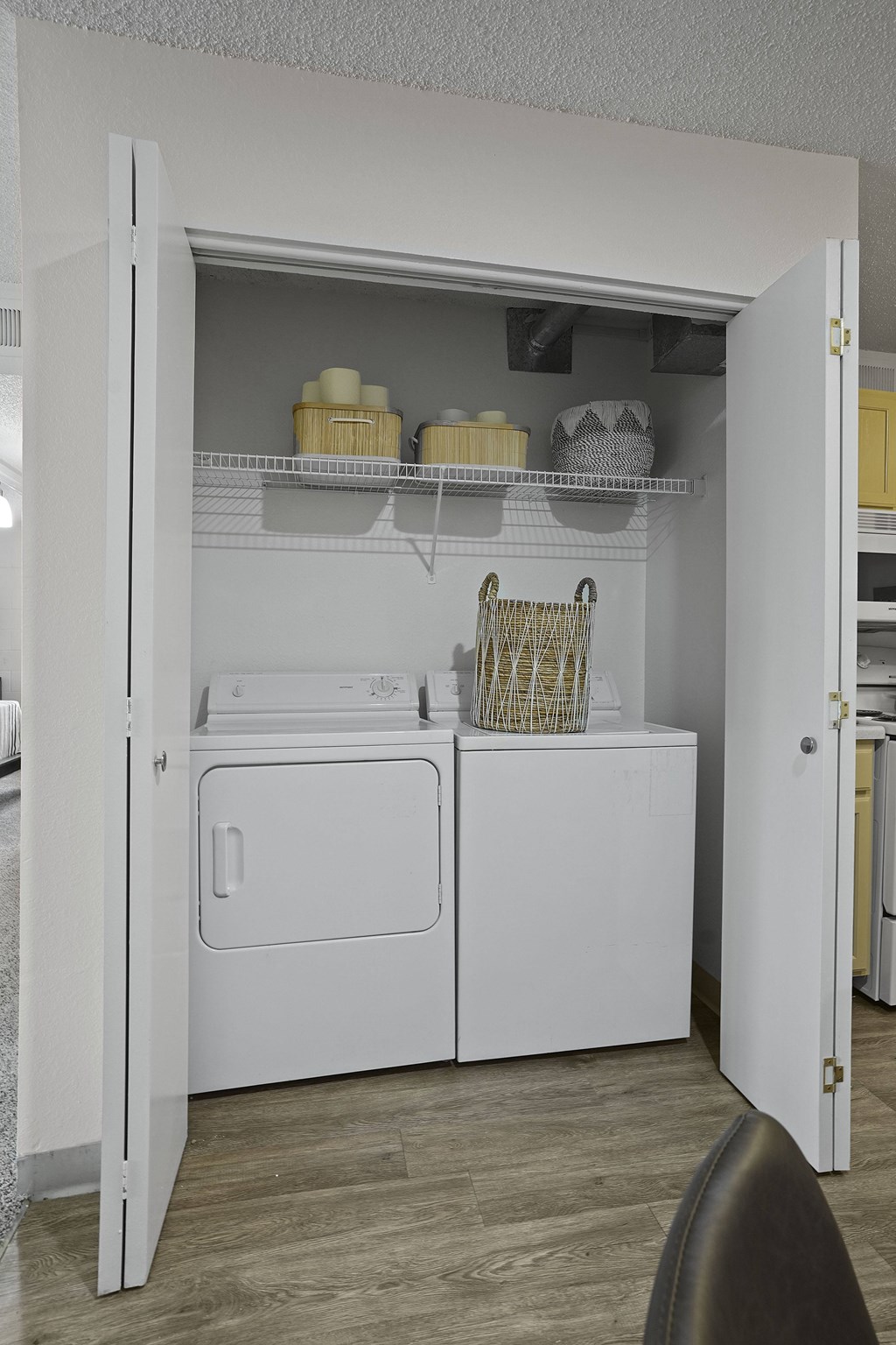A white kitchen pantry with a white fridge and white cupboard.