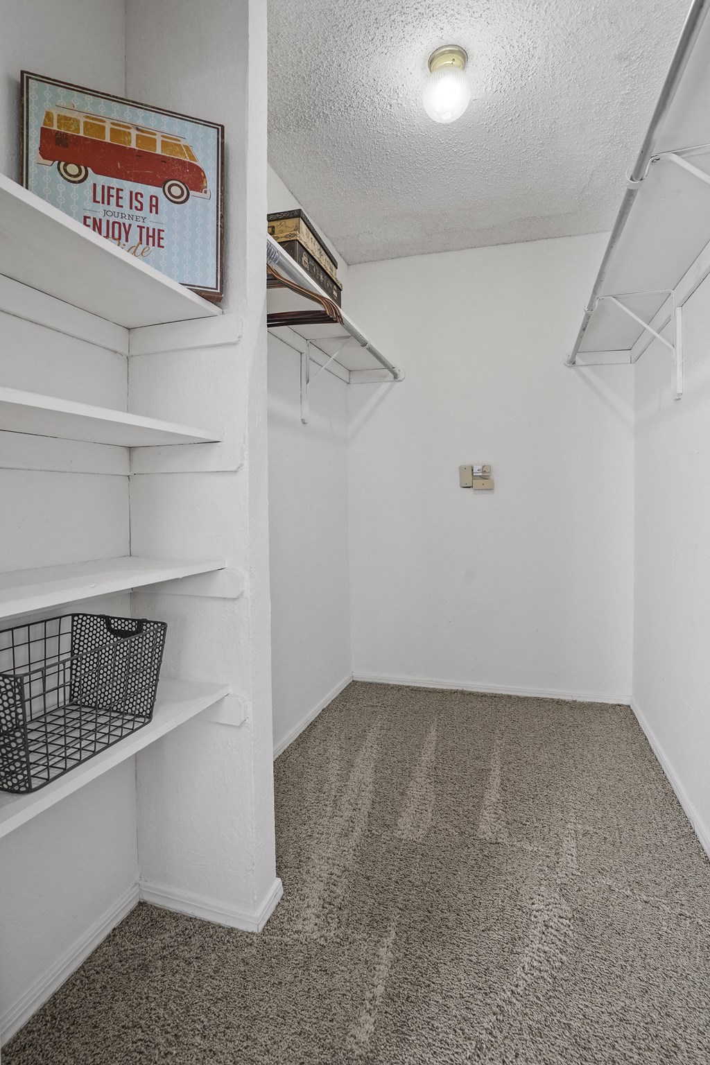 A room with a carpeted floor and a sign that says "Life is a journey, enjoy the ride.".