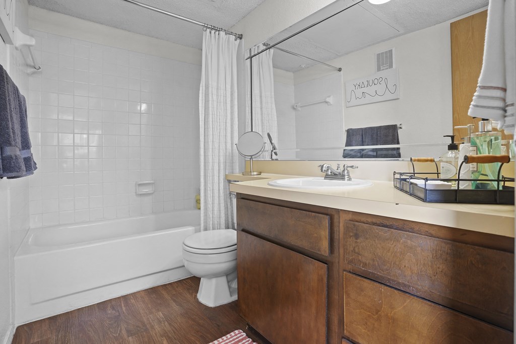 A bathroom with a white tub, toilet, and sink.