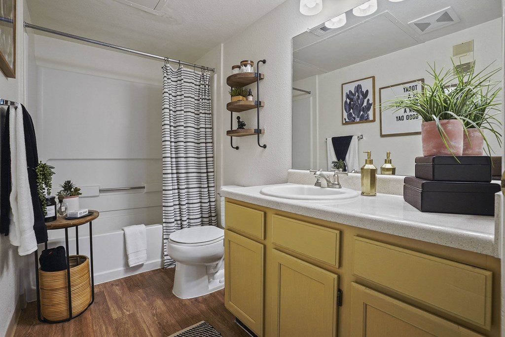 A bathroom with a white toilet, a sink, and a shower curtain.