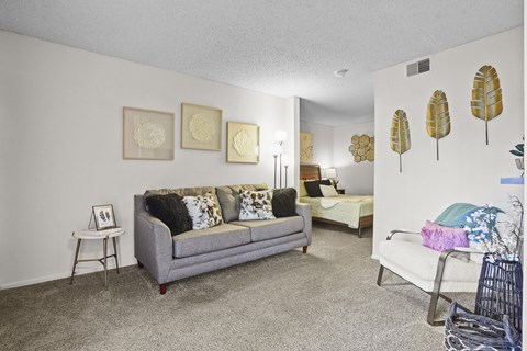 A living room with a grey couch and a white chair.
