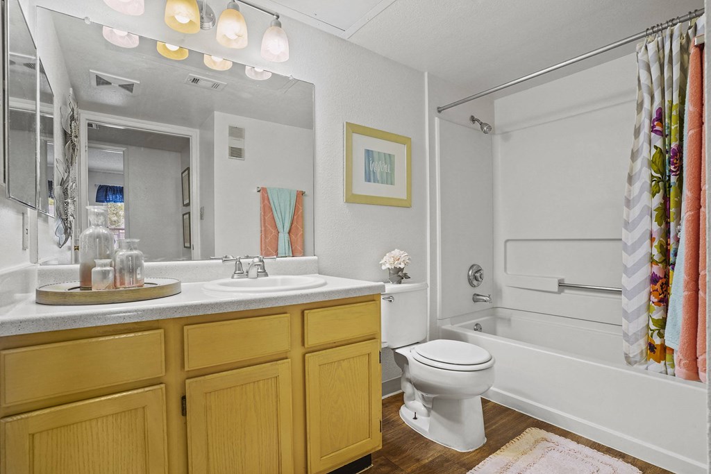 A bathroom with yellow cabinets and a white toilet.