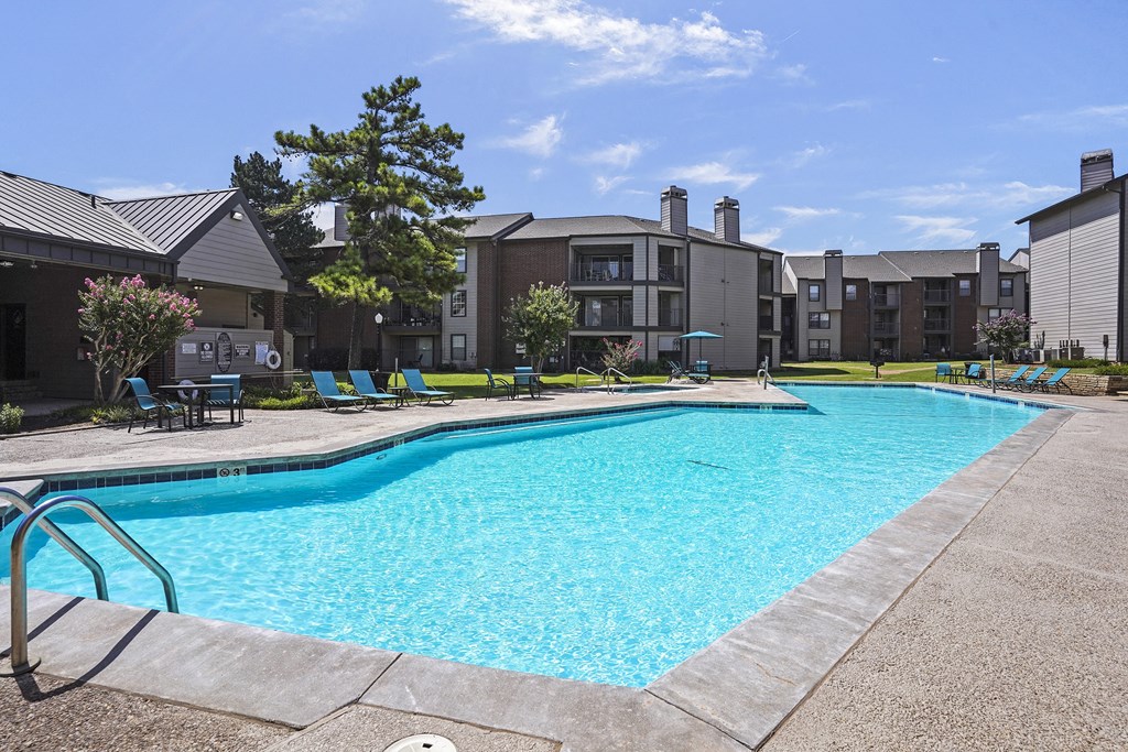 A swimming pool in a residential area with a sunny sky.