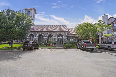 A parking lot with cars and a building in the background.