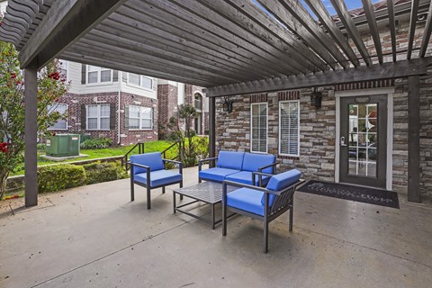 A blue chair and a blue sofa are on a patio.
