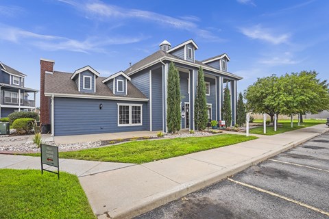 A row of townhouses with a sign in front of the first one.