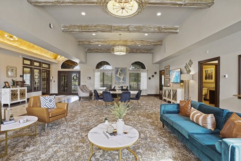 A living room with a large rug and a clock on the wall.