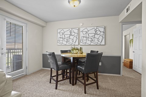 A dining room with a table and chairs.