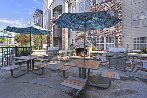 A patio with a table and chairs and a fireplace.