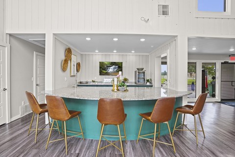A kitchen with a bar and chairs.