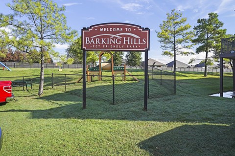 A sign that says "Barking Hills Pet Friendly Park" stands in a grassy area.